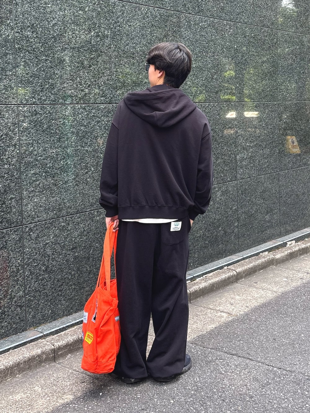 ブラック系のパーカー、ホワイト系のTシャツ/カットソー、ブラック系のスウェットパンツを着用したメンズの秋コーディネートの2枚目の写真