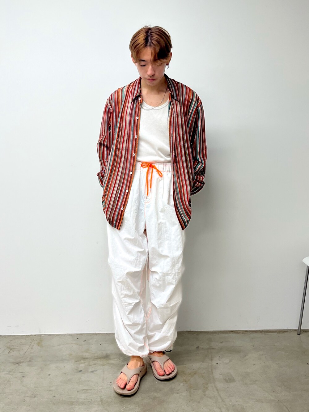 ベージュ系のサンダル、ホワイト系のカーゴパンツ、レッド系のシャツ/ブラウスを着用したメンズの夏コーディネートの2枚目の写真