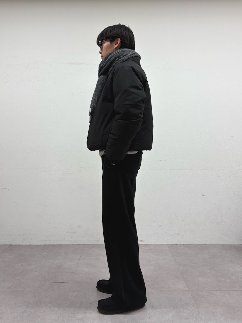 ブラック系のダウンジャケット/コート、ブラック系のその他パンツ、グレー系のマフラーを着用したメンズの冬コーディネートの2枚目の写真