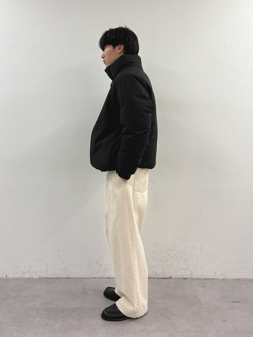 ブラック系のダウンジャケット/コート、ホワイト系のデニムパンツを着用したメンズの冬コーディネートの2枚目の写真