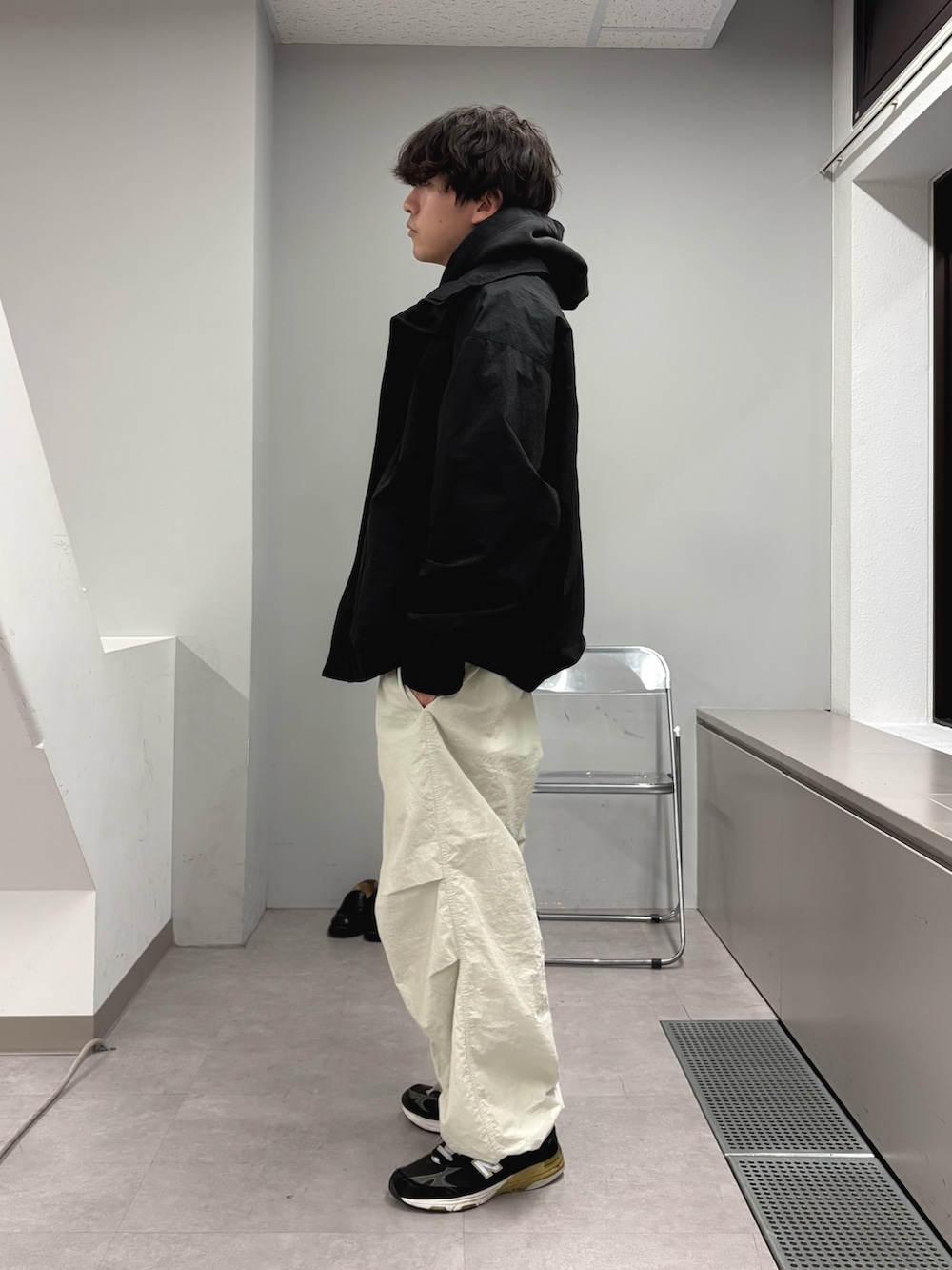 ブラック系のナイロンジャケット、ブラック系のパーカー、グレー系のカーゴパンツを着用したメンズの冬コーディネートの2枚目の写真