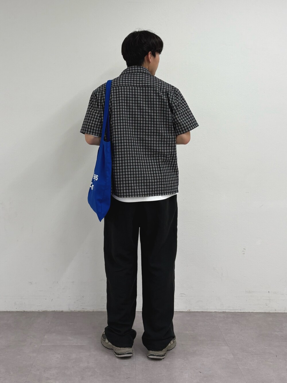 ブラック系のシャツ/ブラウス、ブラック系のスラックス、ブルー系のトートバッグを着用したメンズの夏コーディネートの3枚目の写真