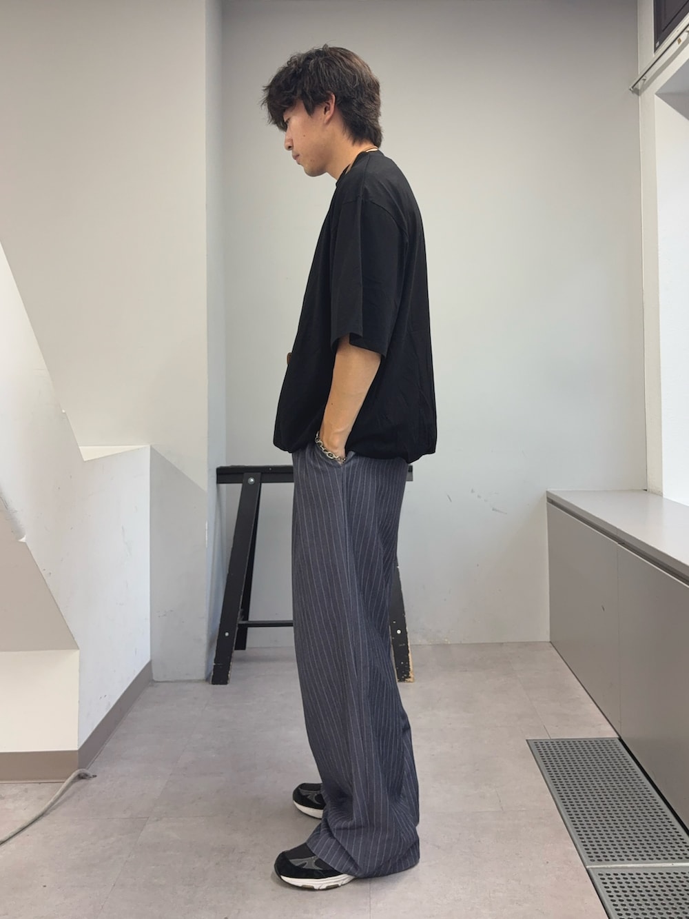 ブラック系のTシャツ/カットソー、グレー系のスラックスを着用したメンズの夏コーディネートの2枚目の写真