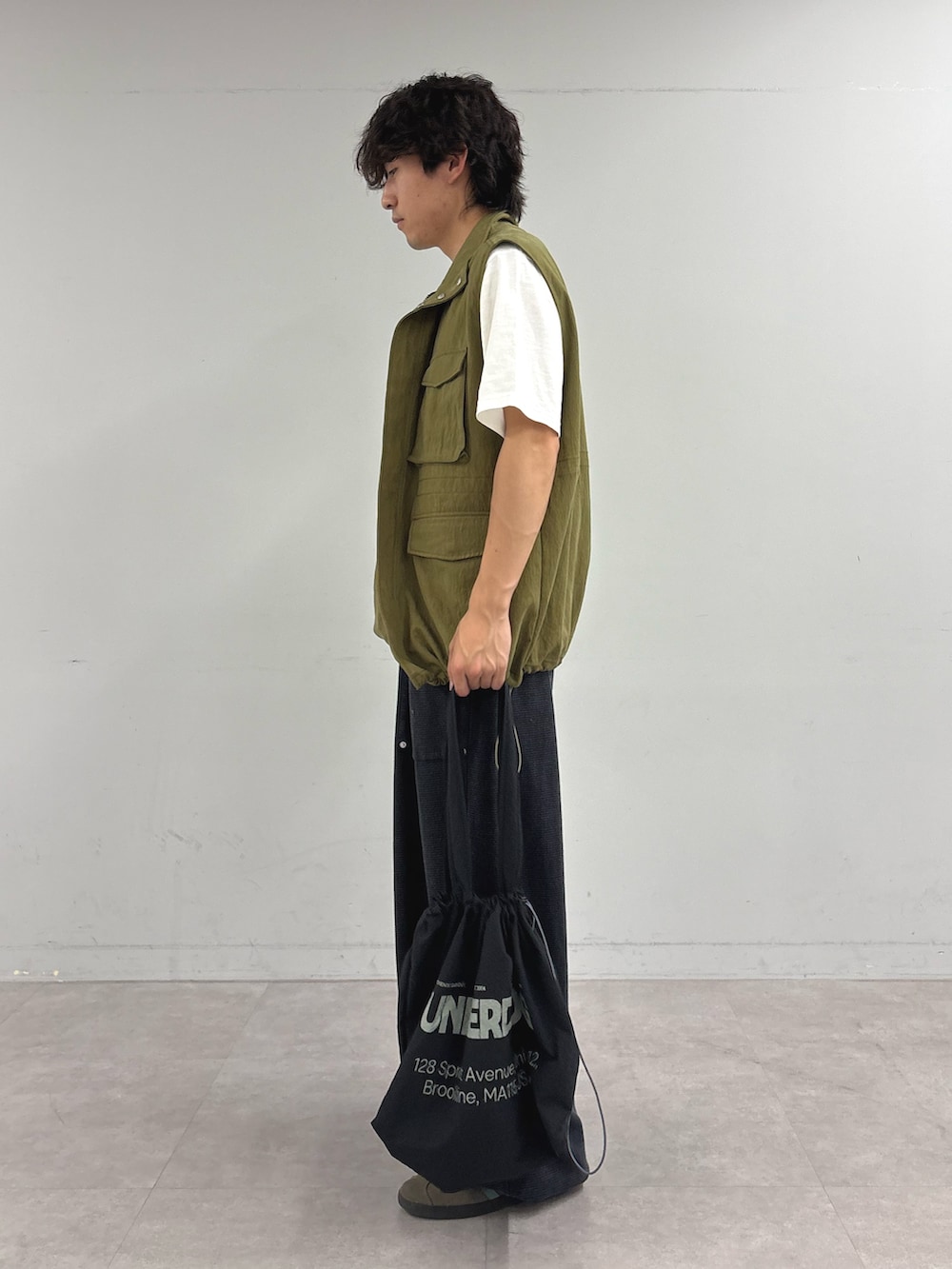 ホワイト系のTシャツ/カットソー、グリーン系のベスト、ブラック系のスウェットパンツを着用したメンズの夏コーディネートの2枚目の写真