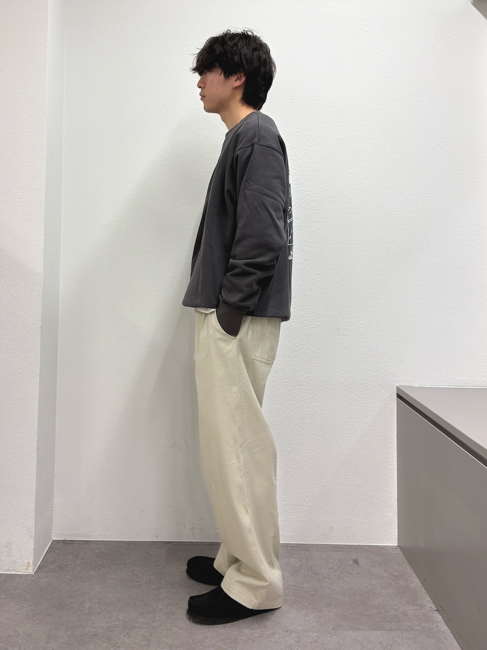 グレー系のスウェット、ホワイト系のチノパンツを着用したメンズの冬コーディネートの2枚目の写真