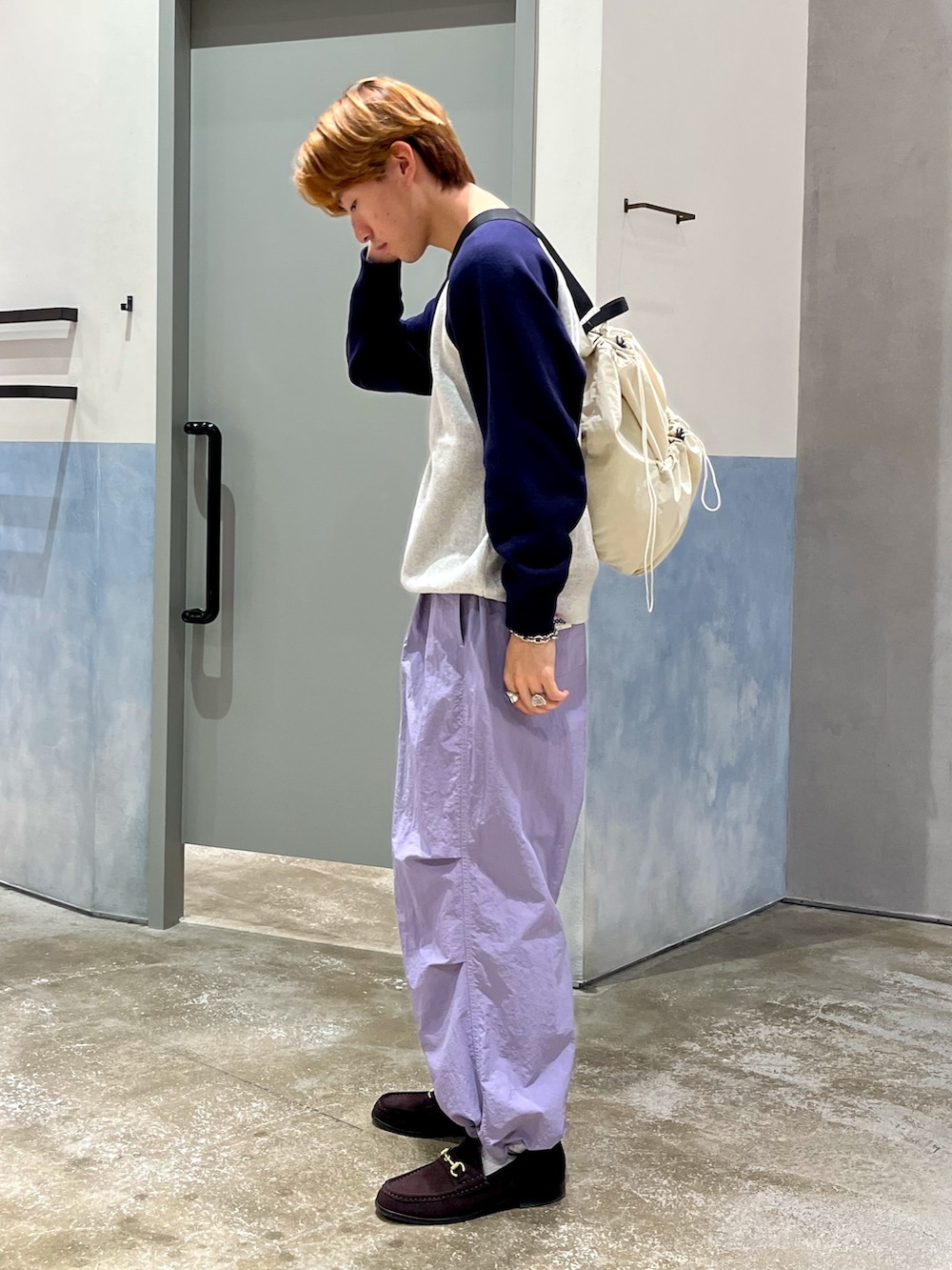 ブラウン系のローファー、パープル系のカーゴパンツ、ブルー系のニット/セーターを着用したメンズの秋コーディネートの2枚目の写真