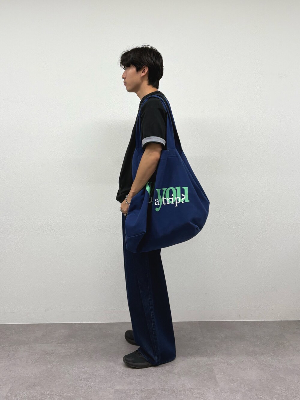 ブラック系のTシャツ/カットソー、ブルー系のデニムパンツ、ブルー系のトートバッグを着用したメンズの秋コーディネートの2枚目の写真
