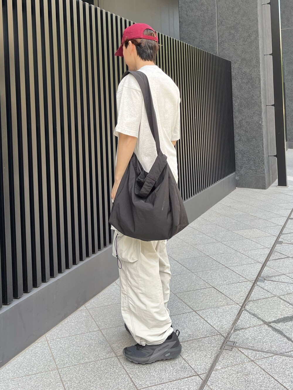 ブラック系のスニーカー、グレー系のサロペット/オーバーオール、ホワイト系のTシャツ/カットソーを着用したメンズの夏コーディネートの2枚目の写真