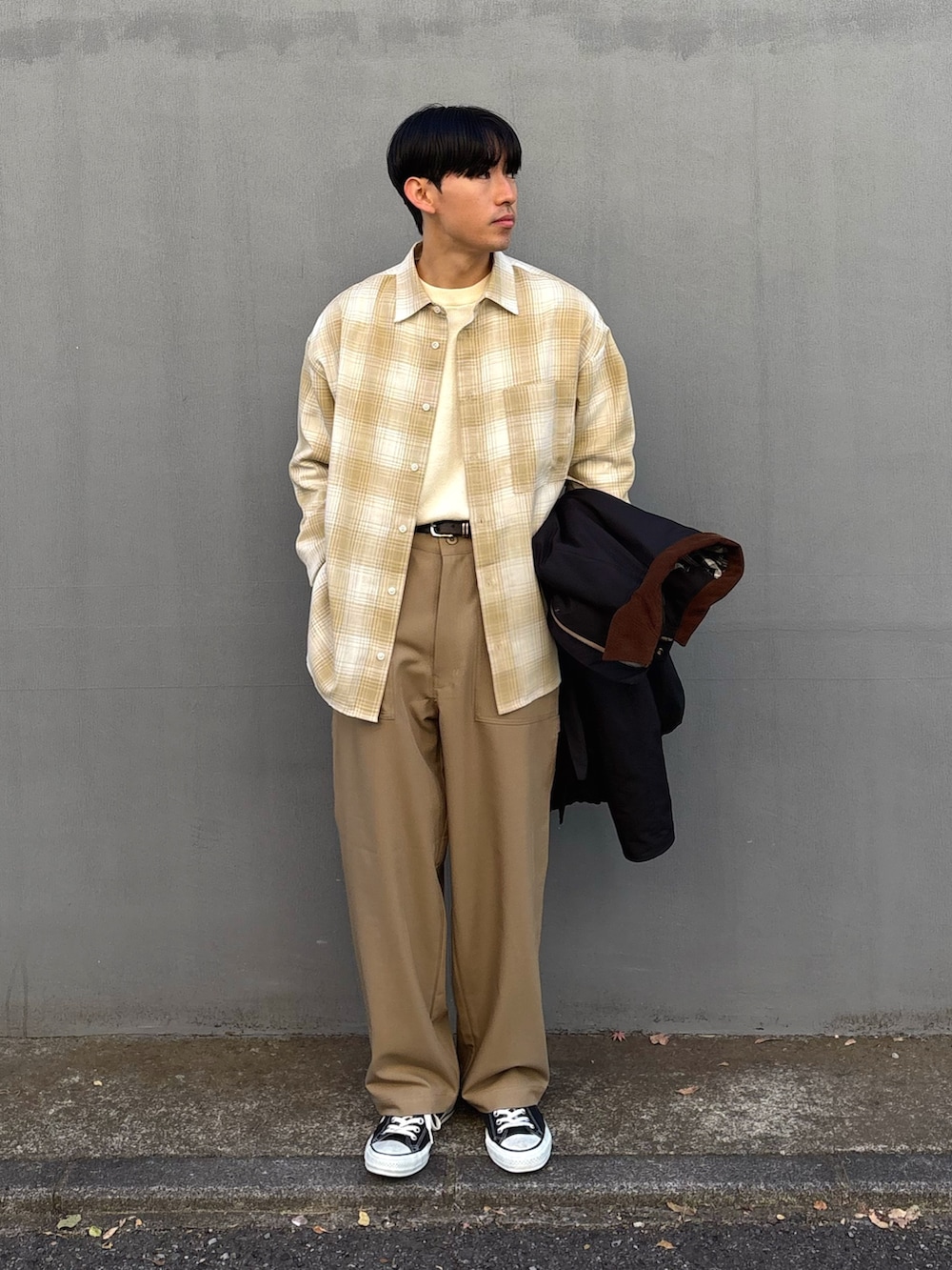 ブラック系のスニーカー、ベージュ系のスラックス、ブラック系のブルゾンを着用したメンズの冬コーディネートの3枚目の写真