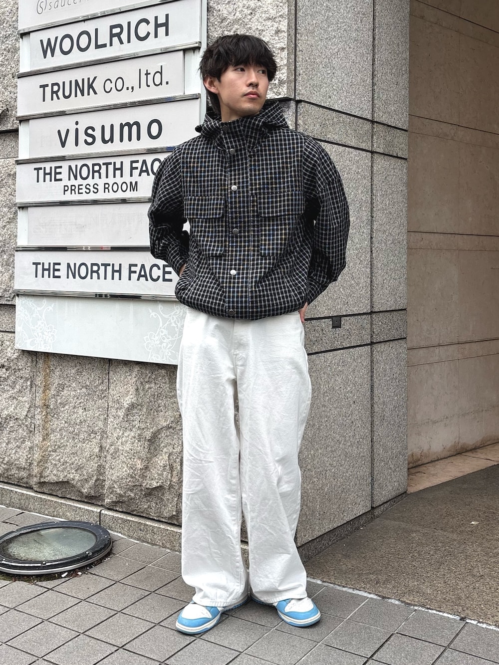 ブラック系のパーカー、ブラック系のナイロンジャケットを着用したメンズの春コーディネートの3枚目の写真