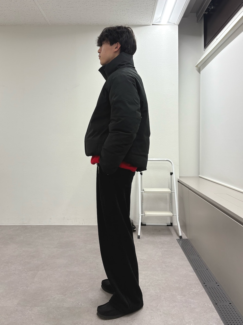 ブラック系のダウンジャケット/コート、レッド系のニット/セーター、ブラック系のその他パンツを着用したメンズの冬コーディネートの2枚目の写真