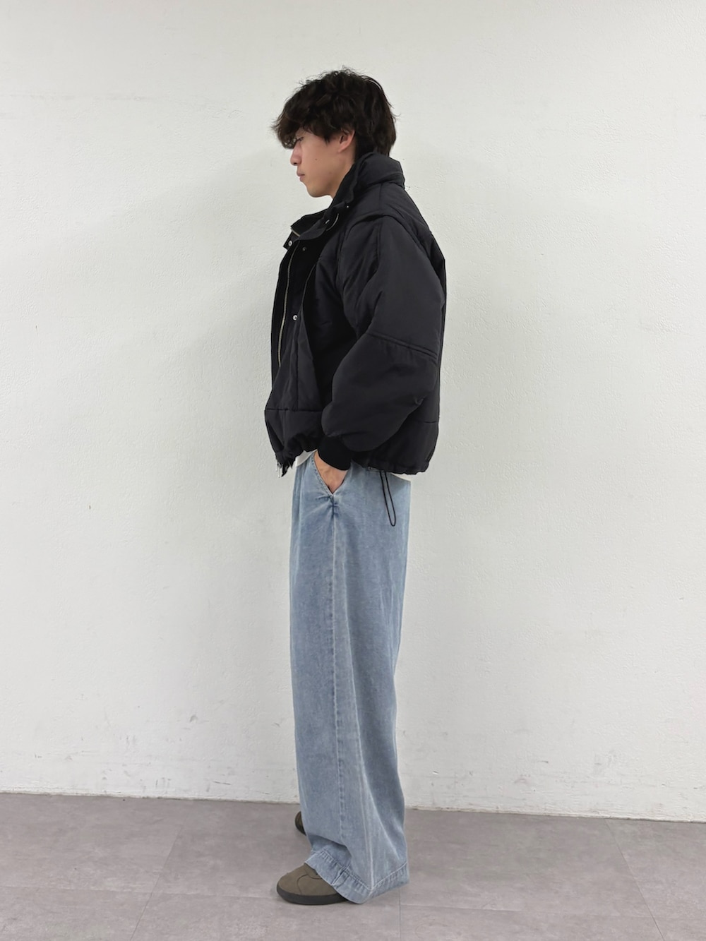 ブラック系のブルゾン、グレー系のスウェット、ブルー系のデニムパンツを着用したメンズの秋コーディネートの2枚目の写真