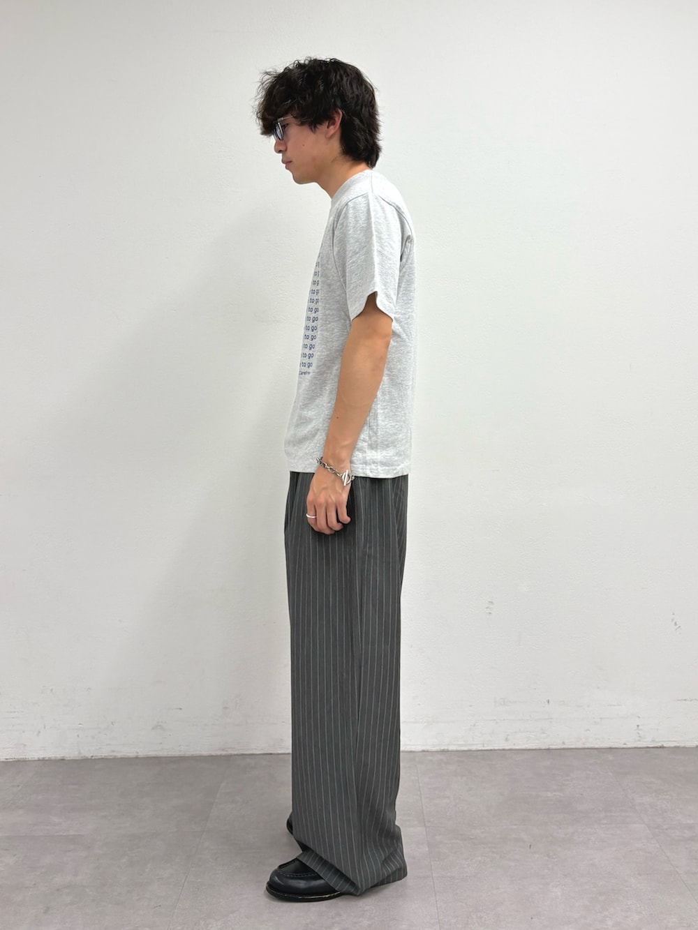 グレー系のTシャツ/カットソー、グレー系のスラックスを着用したメンズの夏コーディネートの2枚目の写真