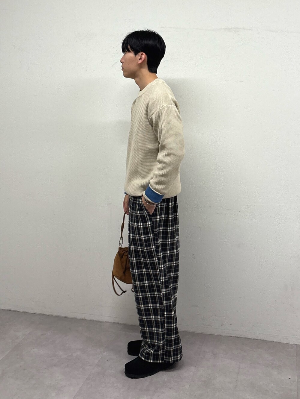 ホワイト系のニット/セーター、ブラック系のその他パンツ、ブラウン系のショルダーバッグを着用したメンズの冬コーディネートの2枚目の写真