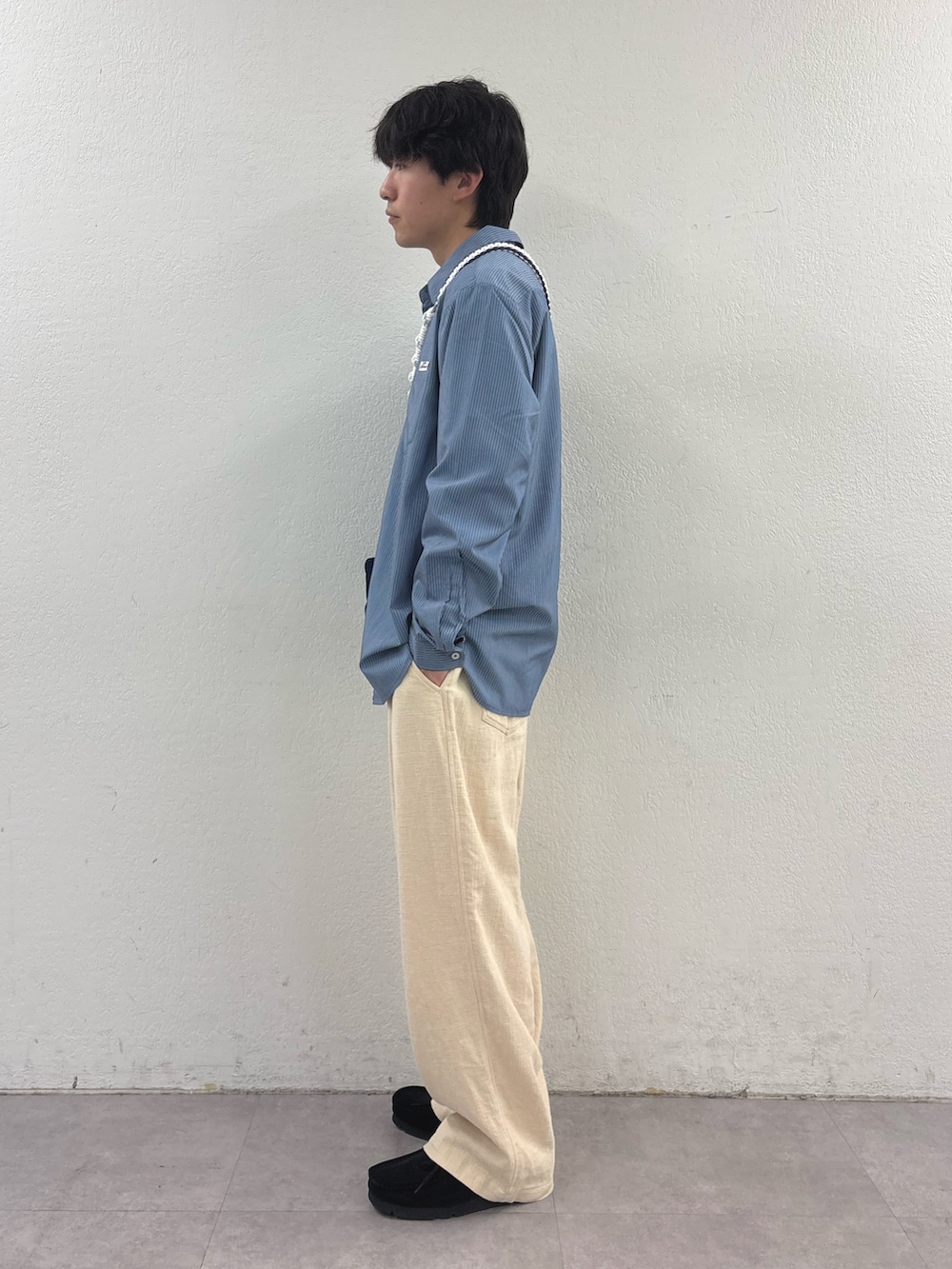 ブルー系のシャツ/ブラウス、ブラック系のショルダーバッグ、ホワイト系のスラックスを着用したメンズの春コーディネートの2枚目の写真