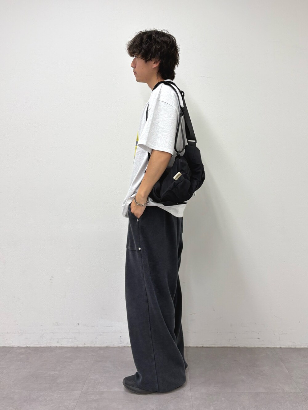 グレー系のTシャツ/カットソー、ブラック系のバックパック/リュック、ブラック系のスウェットパンツを着用したメンズの夏コーディネートの2枚目の写真