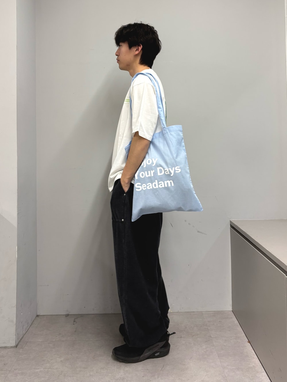 ホワイト系のTシャツ/カットソー、ブルー系のトートバッグ、ブラック系のその他パンツを着用したメンズの春コーディネートの2枚目の写真