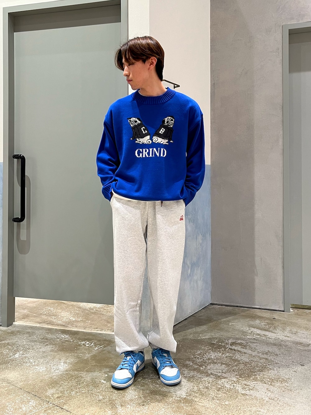 ブラック系のベスト、ブルー系のニット/セーター、グレー系のスウェットパンツを着用したメンズの冬コーディネートの3枚目の写真