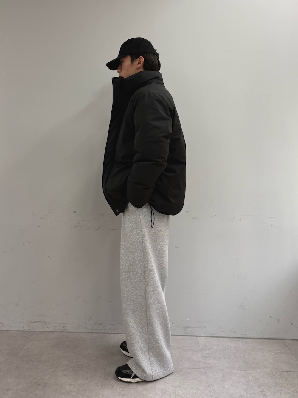 ブラック系のダウンジャケット/コート、グレー系のその他パンツ、ブルー系のスウェットを着用したメンズの冬コーディネートの2枚目の写真