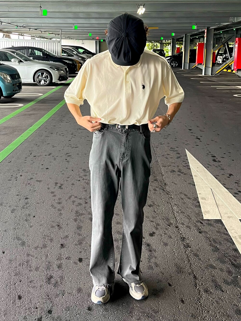 ホワイト系のポロシャツ、グレー系のその他パンツ、グレー系のスニーカーを着用したメンズの夏コーディネートの2枚目の写真