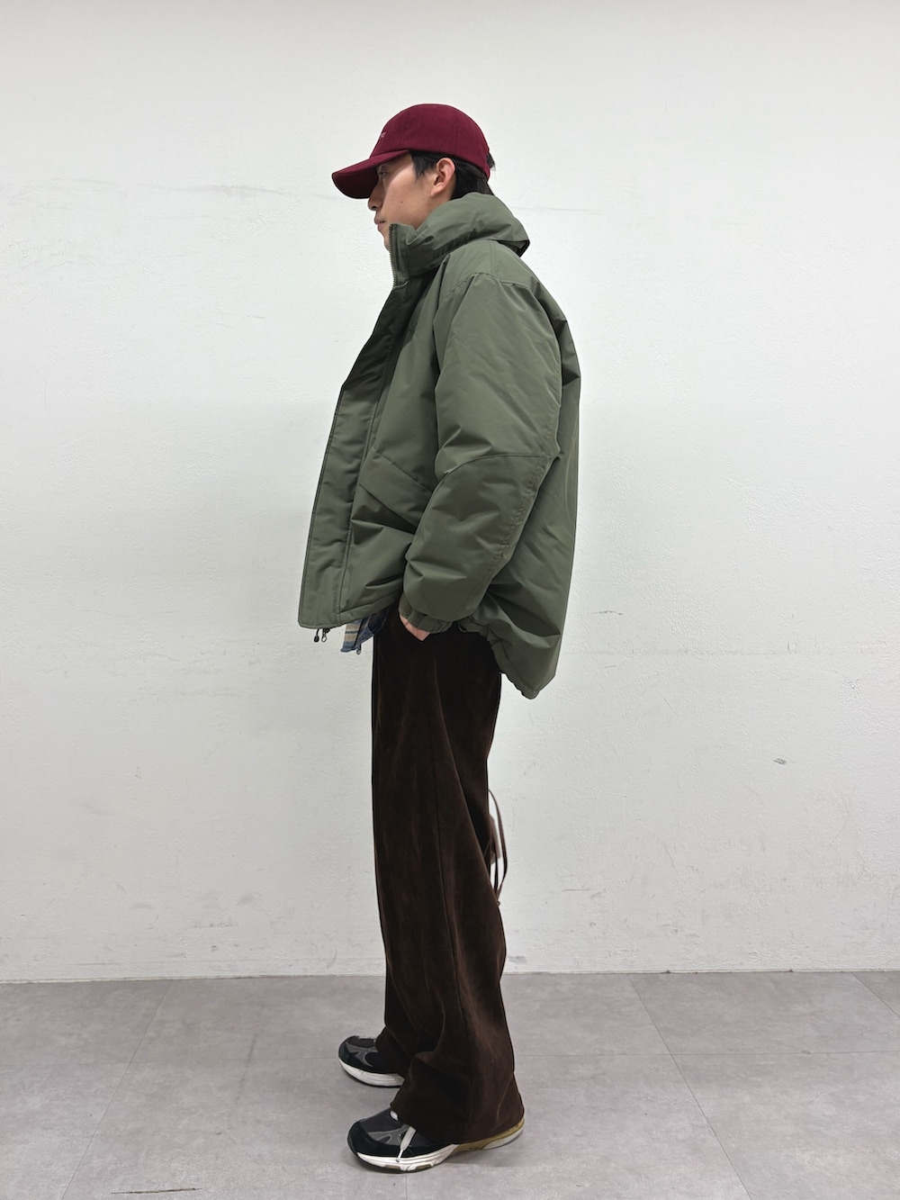 グリーン系のダウンジャケット/コート、ベージュ系のシャツ/ブラウス、ブラウン系のショルダーバッグを着用したメンズの冬コーディネートの2枚目の写真