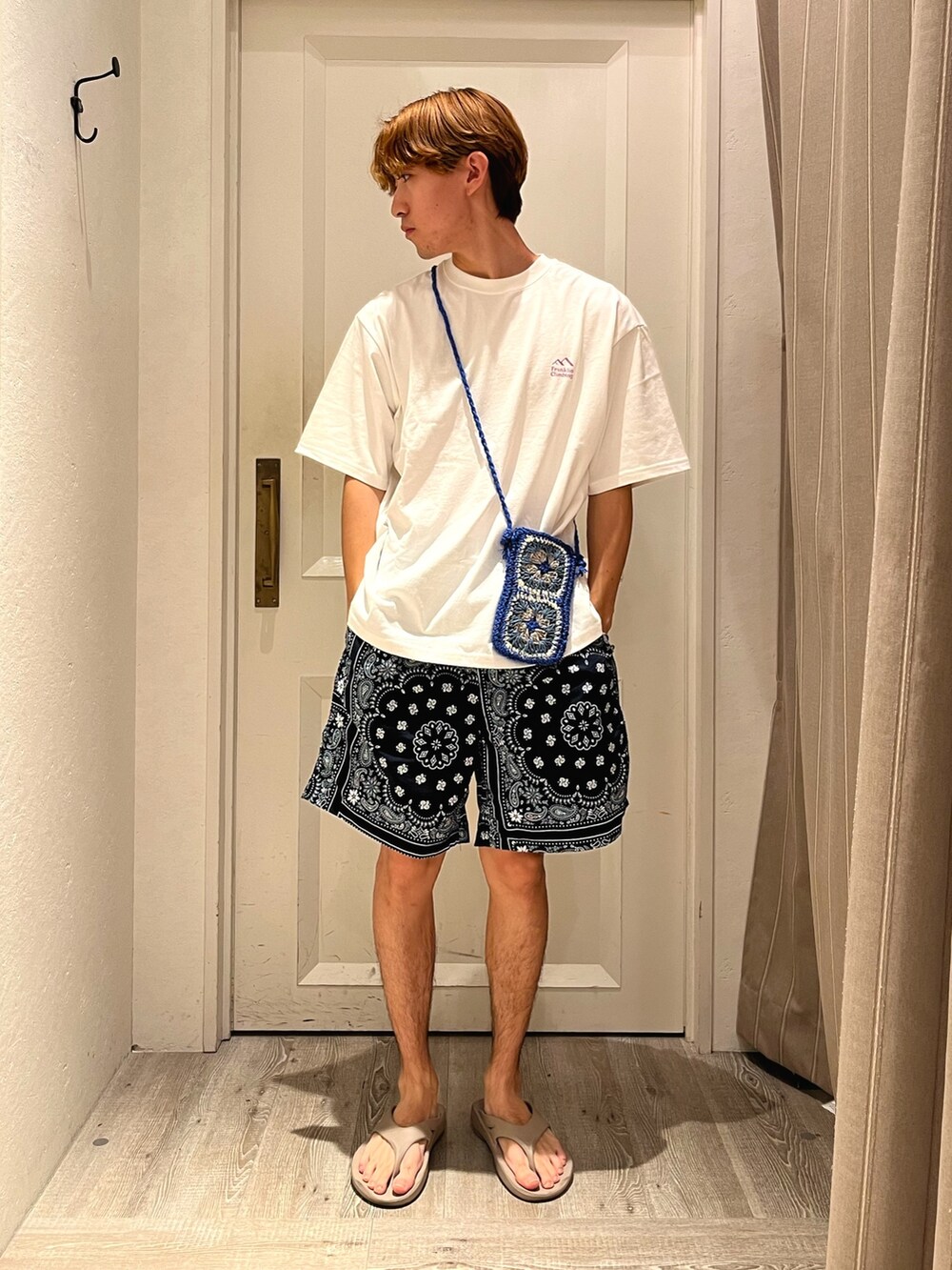 ホワイト系のTシャツ/カットソー、ブルー系のパンツ、ベージュ系のサンダルを着用したメンズの夏コーディネートの2枚目の写真