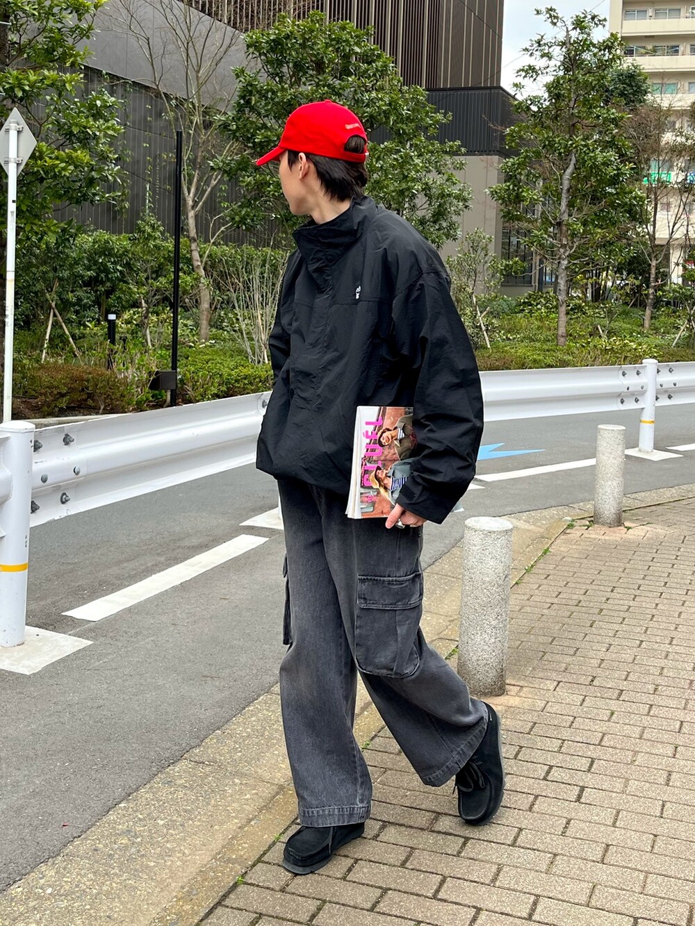 ブラック系のスニーカー、ブラック系のカーゴパンツ、ブラック系のナイロンジャケットを着用したメンズの春コーディネートの2枚目の写真