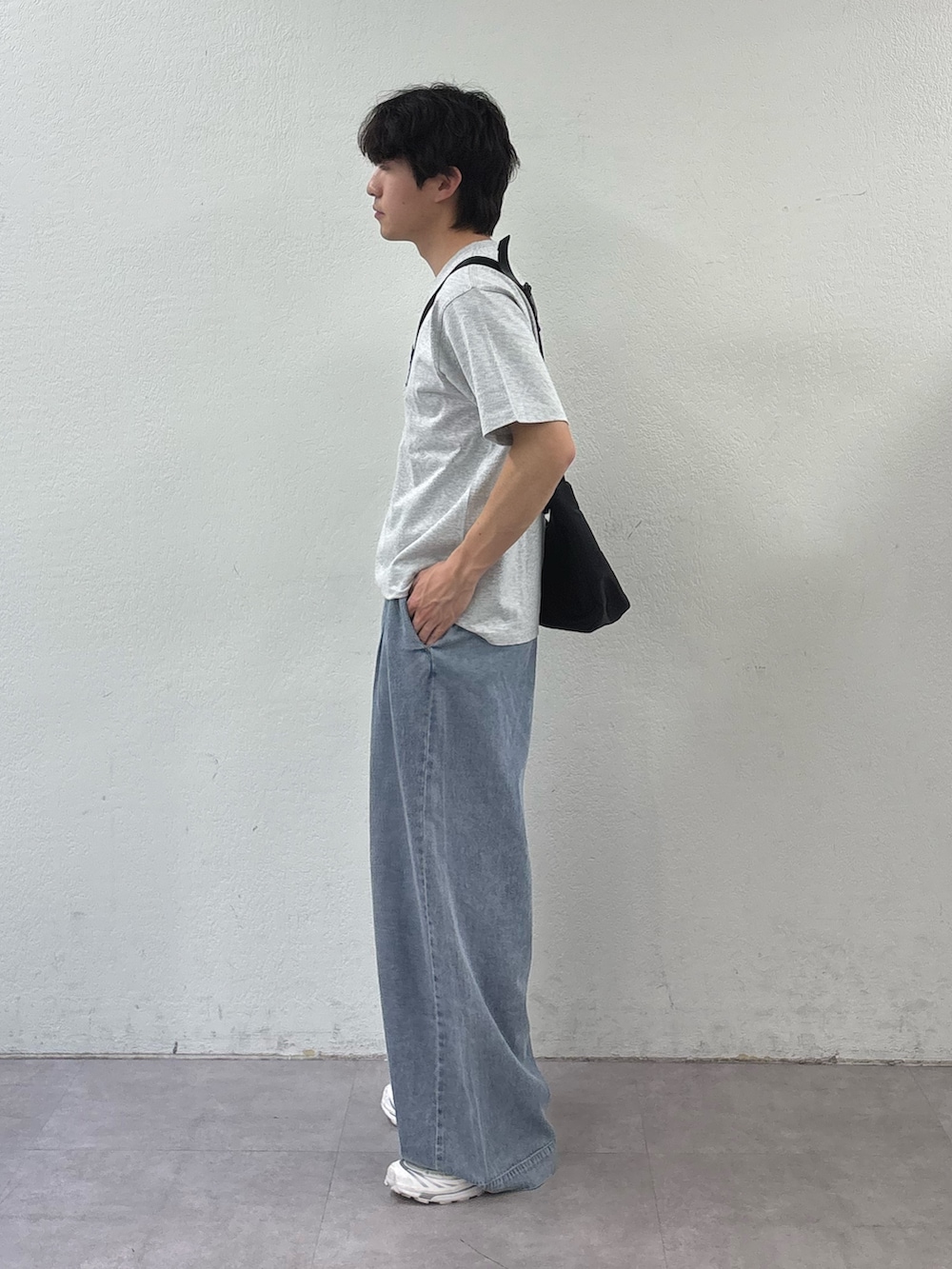 グレー系のTシャツ/カットソー、ブラック系のショルダーバッグ、ブルー系のデニムパンツを着用したメンズの春コーディネートの2枚目の写真