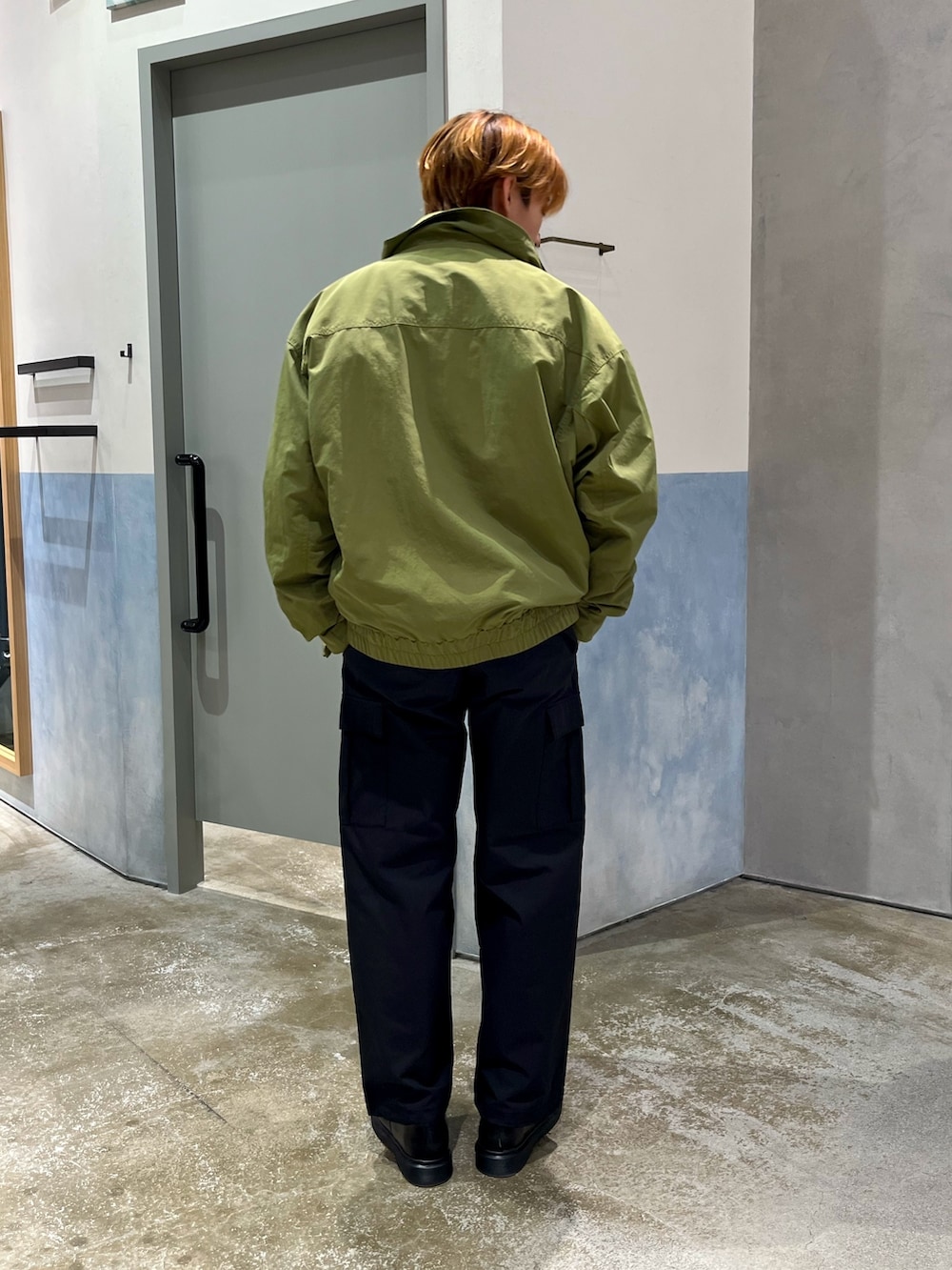 ブラック系のその他シューズ、ブラック系のカーゴパンツ、グリーン系のナイロンジャケットを着用したメンズの秋コーディネートの3枚目の写真