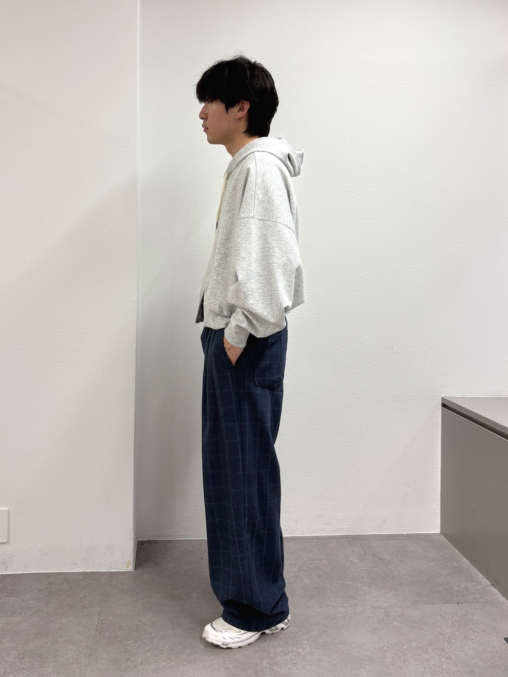 グレー系のパーカー、ブルー系のスラックスを着用したメンズの春コーディネートの2枚目の写真