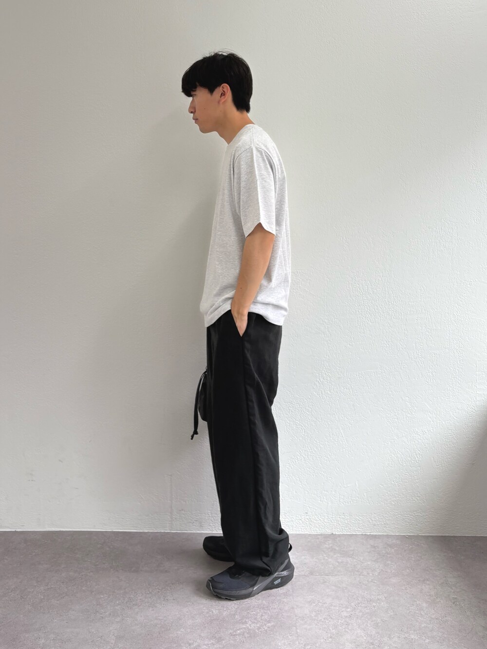 グレー系のTシャツ/カットソー、ブラック系のスラックス、ブラック系のショルダーバッグを着用したメンズの夏コーディネートの2枚目の写真