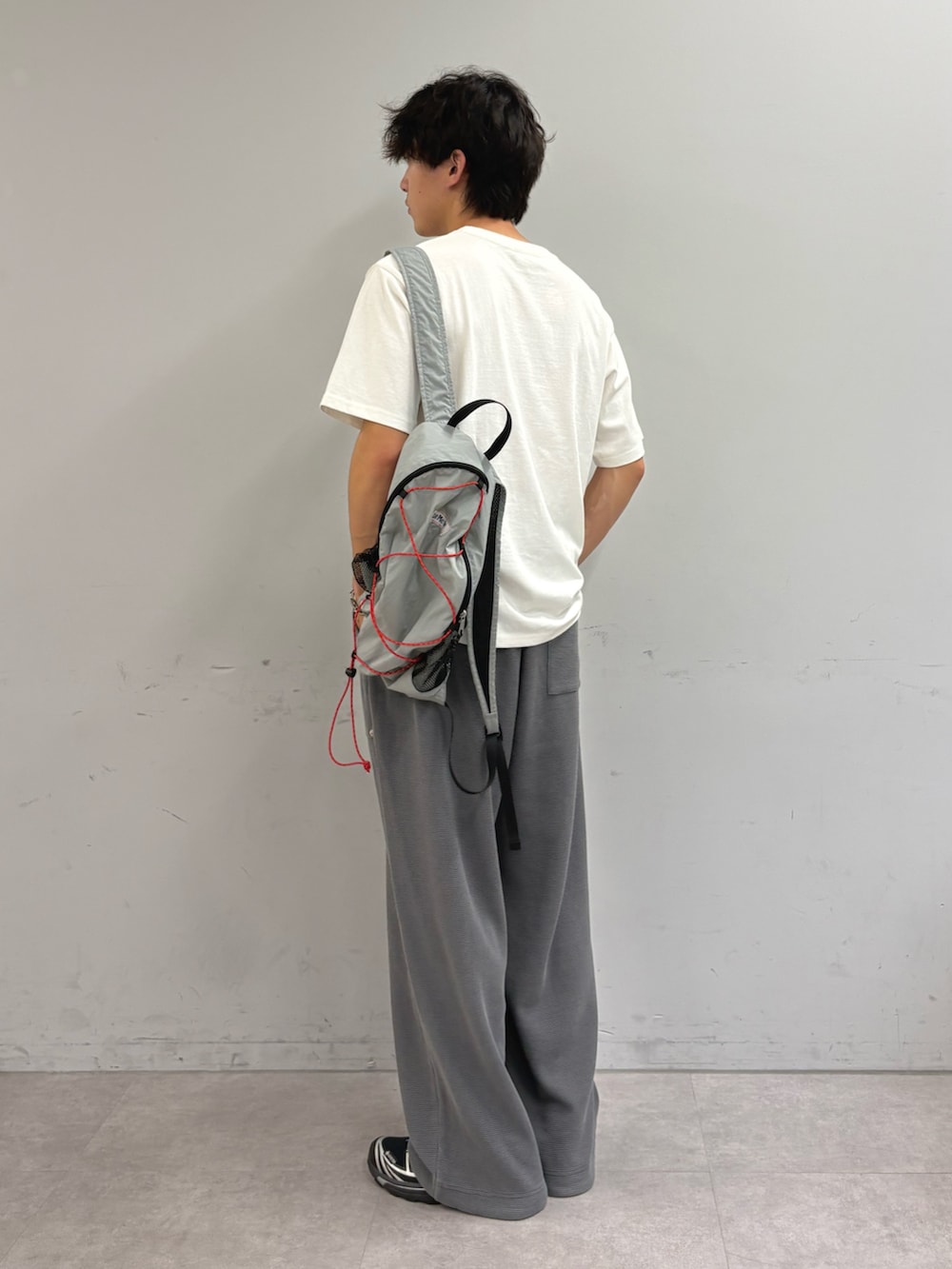 ホワイト系のTシャツ/カットソー、グレー系のバックパック/リュック、グレー系のスウェットパンツを着用したメンズの秋コーディネートの2枚目の写真