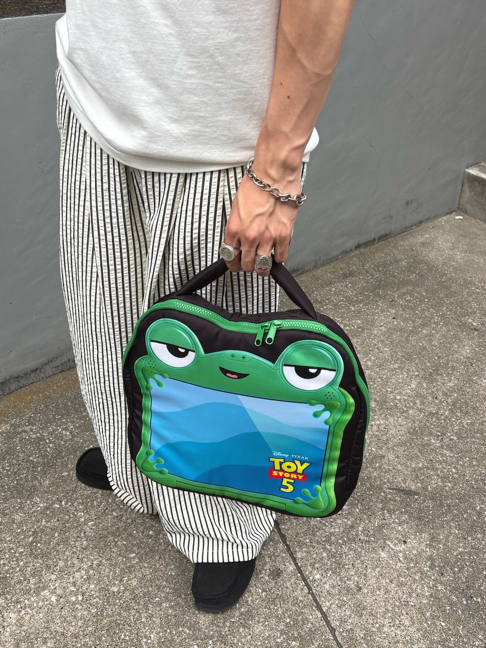 ホワイト系のTシャツ/カットソー、ホワイト系のその他パンツ、ブラック系のPC・タブレットケースを着用したメンズの春コーディネートの3枚目の写真