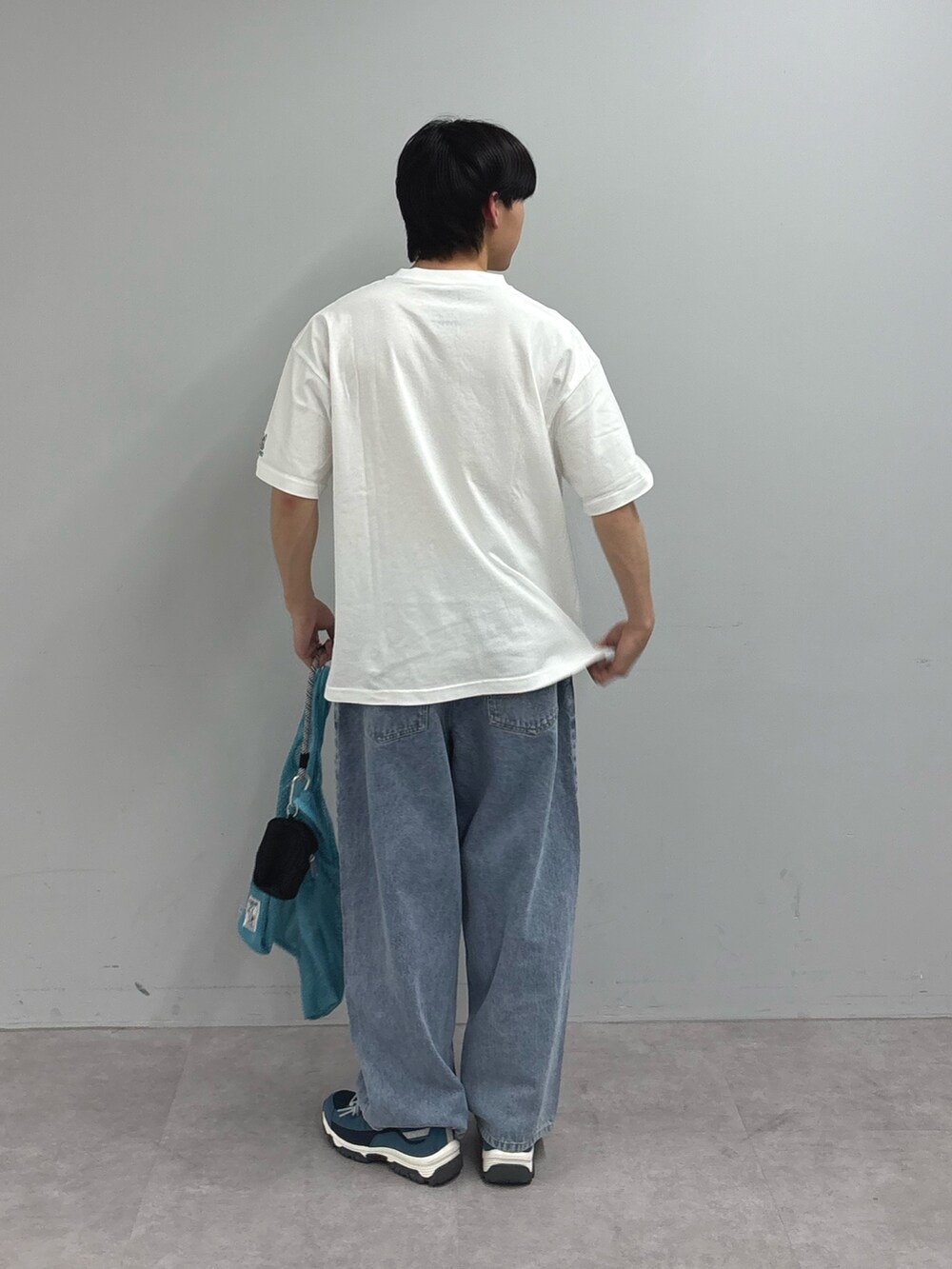 ホワイト系のTシャツ/カットソー、ブルー系のデニムパンツ、ブルー系のスニーカーを着用したメンズの春コーディネートの3枚目の写真