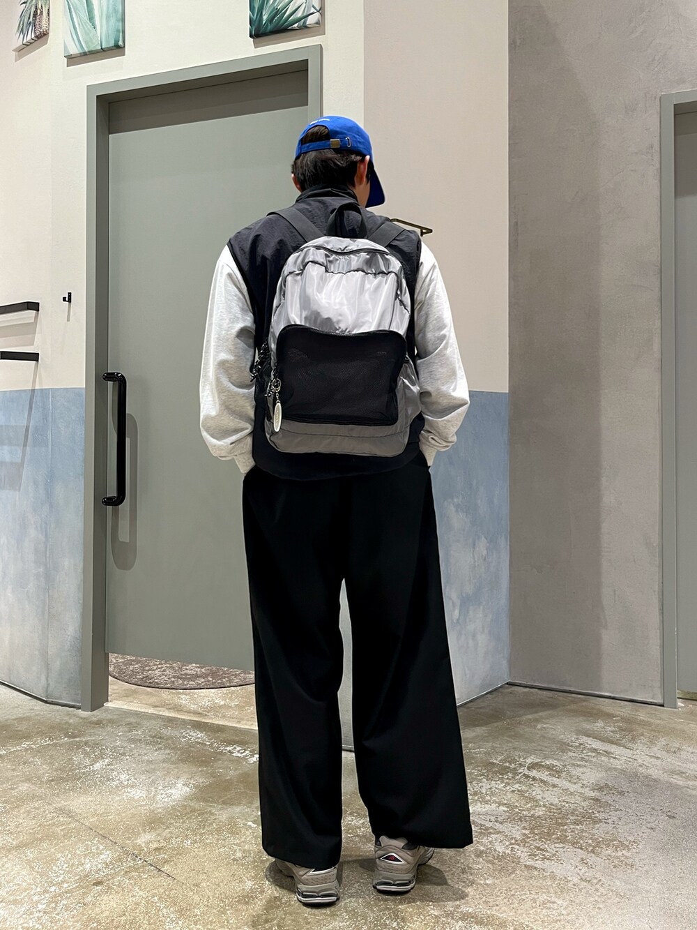 グレー系のスニーカー、ブラック系のスラックス、グレー系のスウェットを着用したメンズの春コーディネートの3枚目の写真