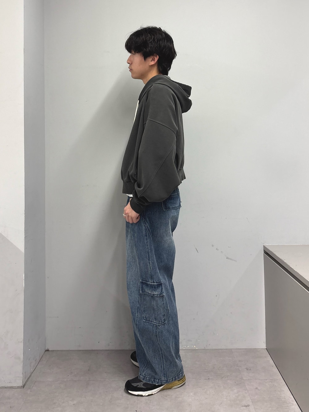 グレー系のパーカー、ブルー系のカーゴパンツを着用したメンズの春コーディネートの2枚目の写真