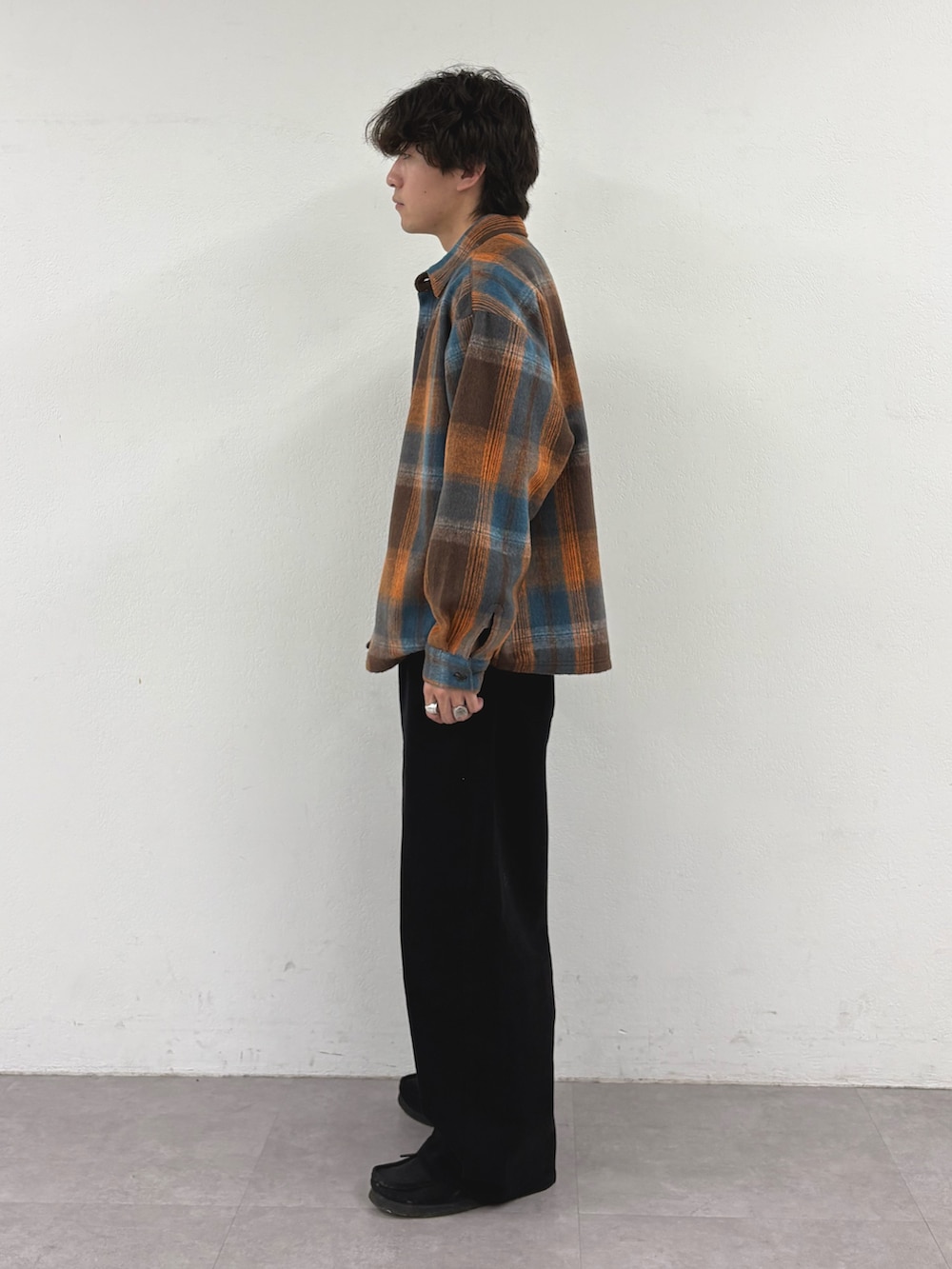 オレンジ系のシャツ/ブラウス、ホワイト系のTシャツ/カットソー、ブラック系のデニムパンツを着用したメンズの秋コーディネートの2枚目の写真