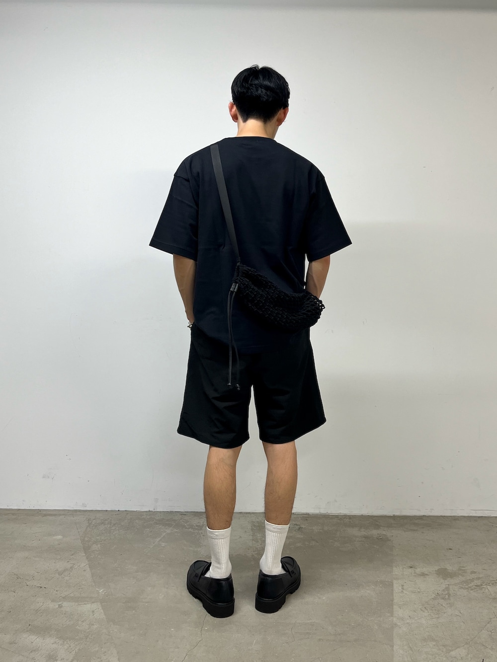 ブラック系のその他パンツ、ブラック系のローファー、ブラック系のTシャツ/カットソーを着用したメンズの夏コーディネートの3枚目の写真
