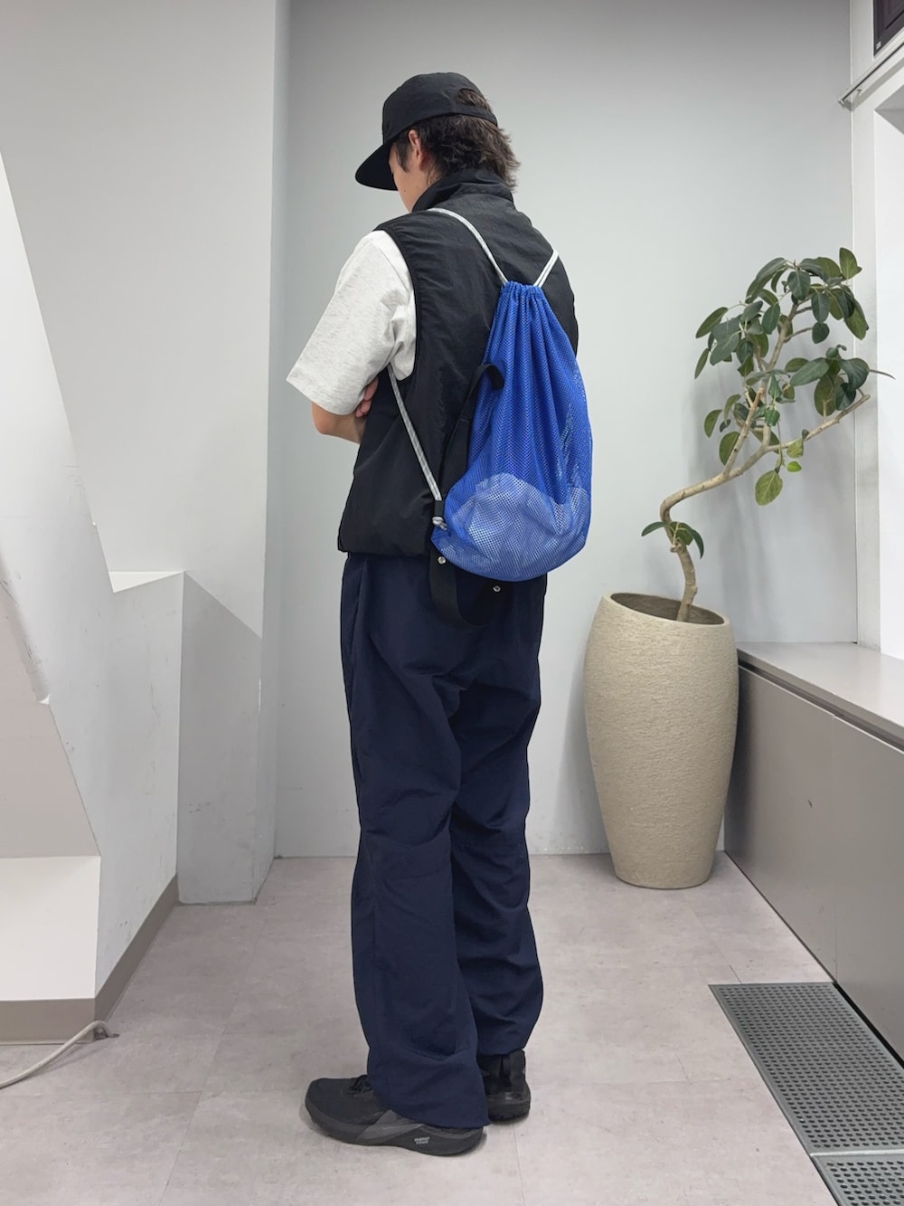 ブラック系のベスト、ブルー系のトートバッグ、ブルー系のその他パンツを着用したメンズの夏コーディネートの2枚目の写真