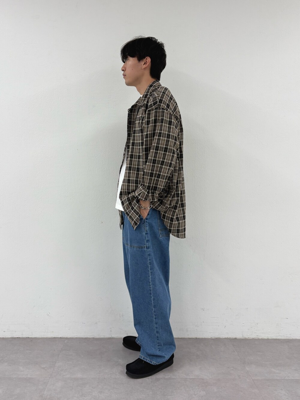 ブラウン系のシャツ/ブラウス、ホワイト系のTシャツ/カットソー、ブルー系のデニムパンツを着用したメンズの秋コーディネートの2枚目の写真