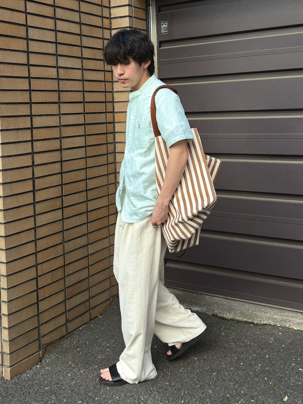 グリーン系のシャツ/ブラウス、ホワイト系のスラックスを着用したメンズの春コーディネートの2枚目の写真