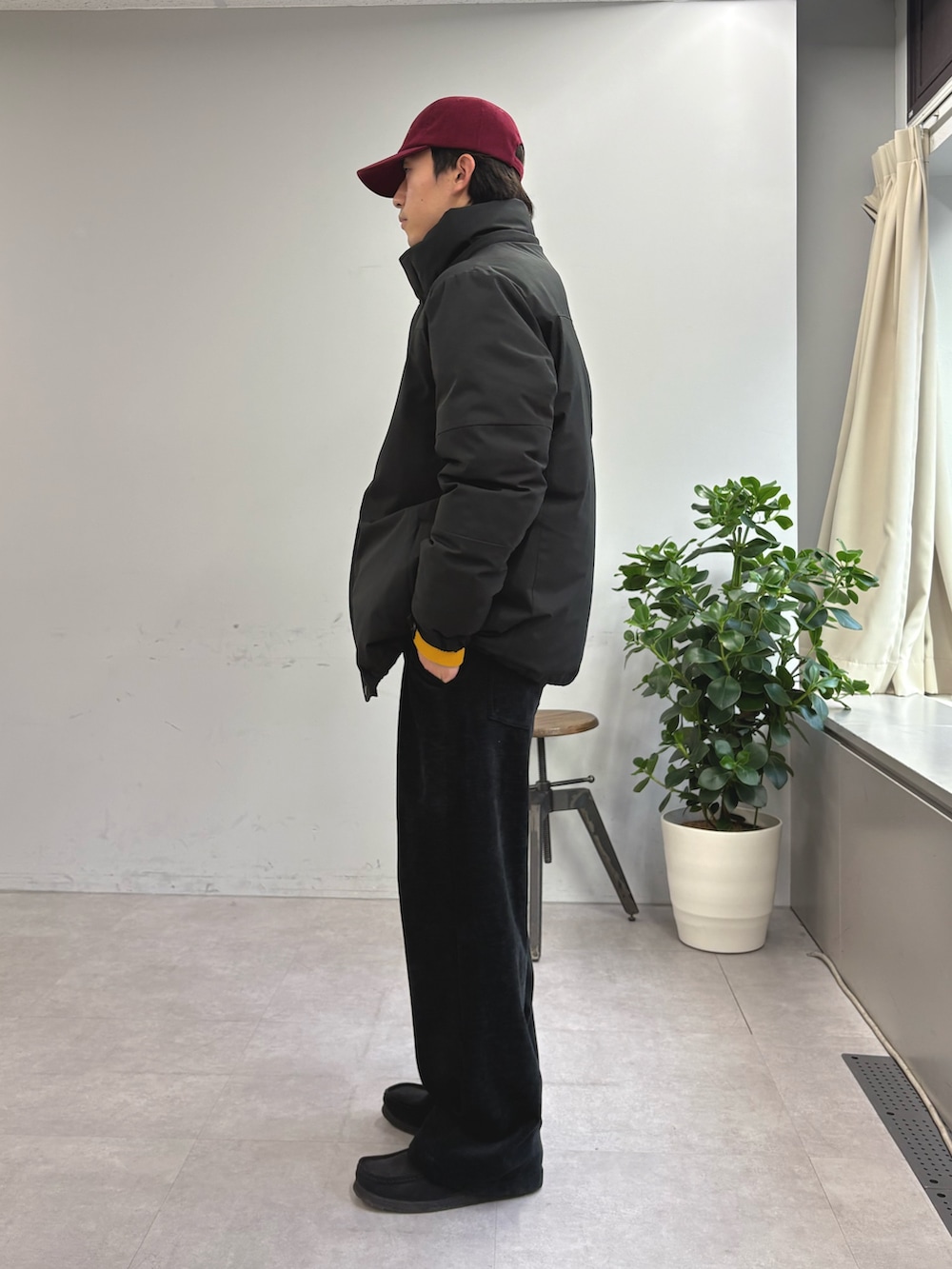 ブラック系のダウンジャケット/コート、イエロー系のニット/セーター、ブラック系のその他パンツを着用したメンズの冬コーディネートの2枚目の写真