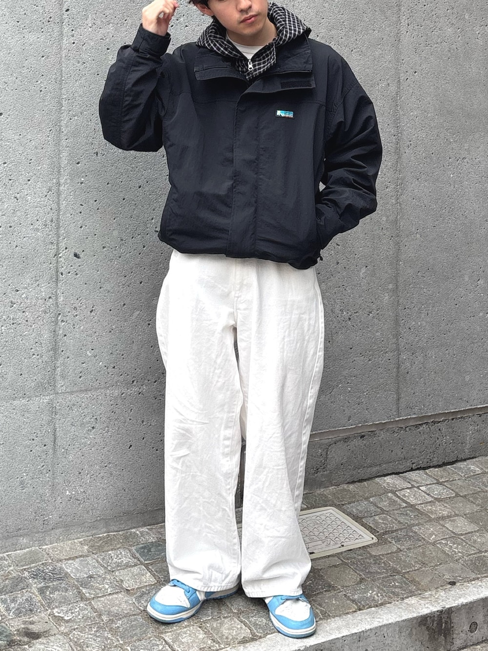 ブラック系のパーカー、ブラック系のナイロンジャケットを着用したメンズの春コーディネートの2枚目の写真