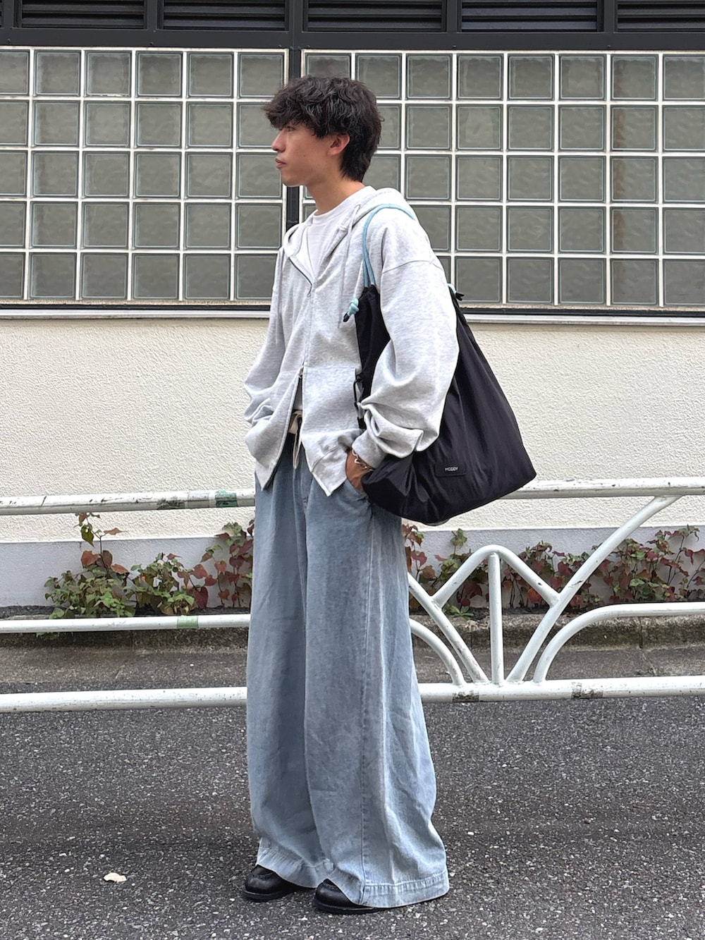 グレー系のパーカー、ブルー系のデニムパンツを着用したメンズの夏コーディネートの2枚目の写真