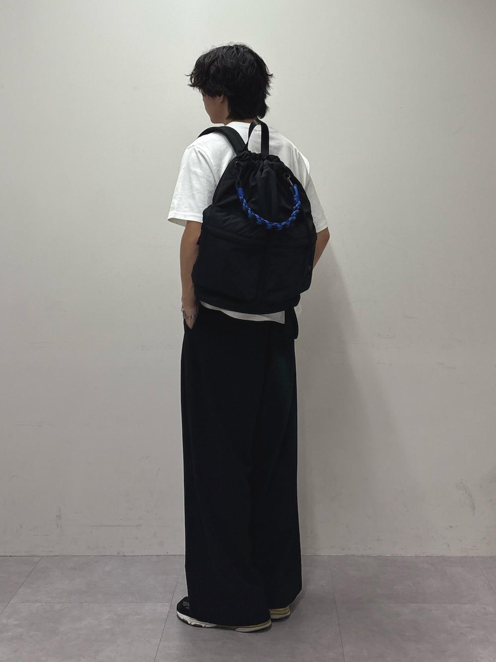 ホワイト系のTシャツ/カットソー、ブラック系のバックパック/リュック、ブラック系のスラックスを着用したメンズの夏コーディネートの2枚目の写真