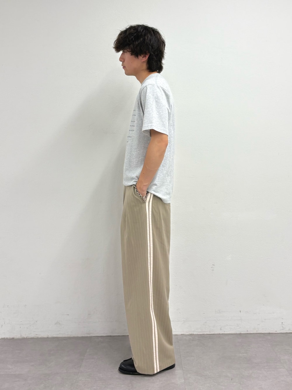 グレー系のTシャツ/カットソー、ベージュ系のスラックスを着用したメンズの夏コーディネートの2枚目の写真