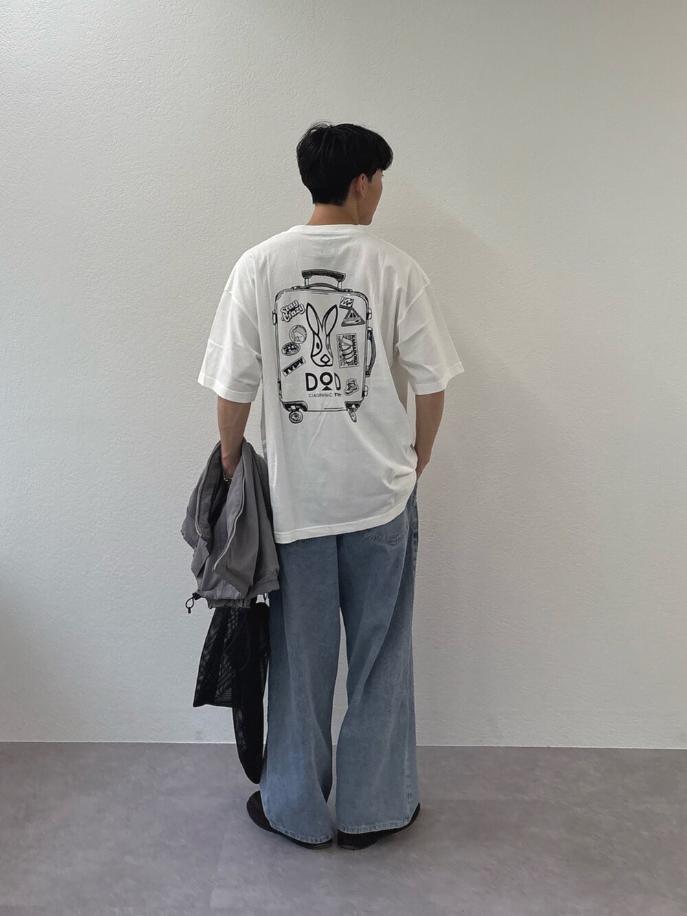 グレー系のベスト、ブルー系のデニムパンツ、ホワイト系のTシャツ/カットソーを着用したメンズの春コーディネートの3枚目の写真