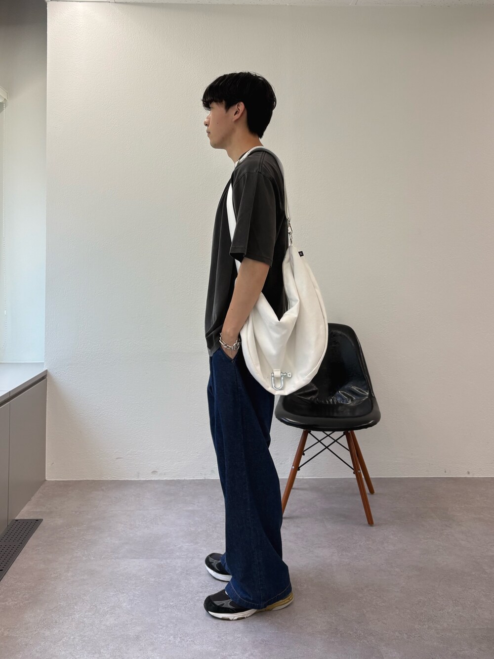 ブラック系のTシャツ/カットソー、ホワイト系のショルダーバッグ、ブルー系のデニムパンツを着用したメンズの夏コーディネートの3枚目の写真