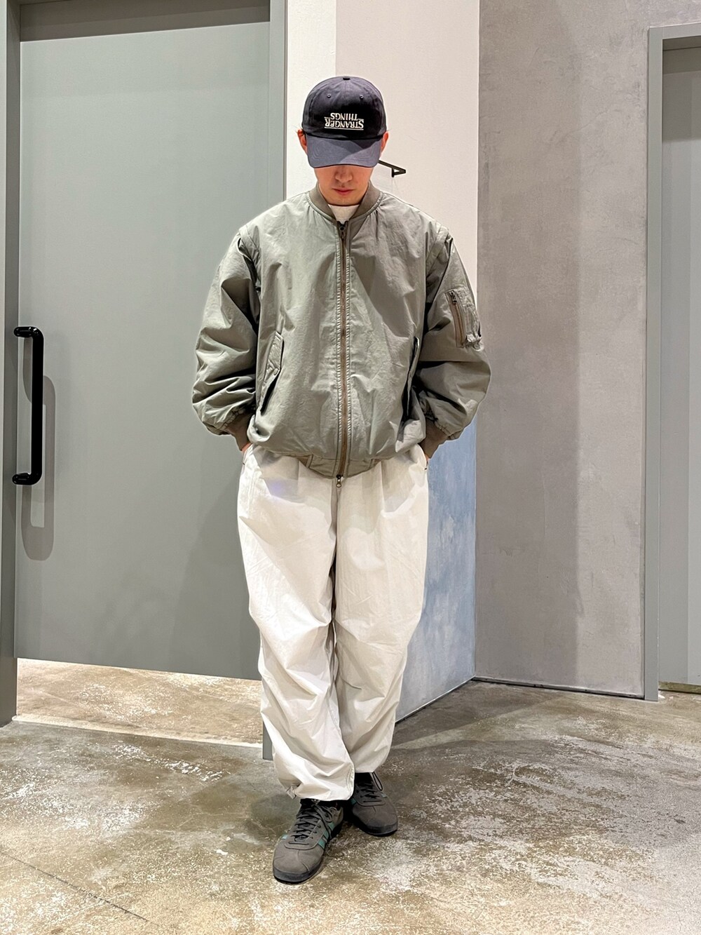 グレー系のスニーカー、グレー系のカーゴパンツ、ホワイト系のスウェットを着用したメンズの冬コーディネートの2枚目の写真