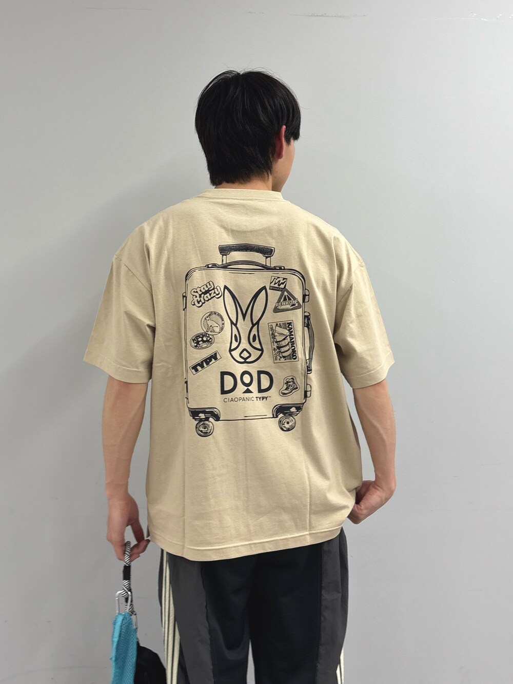 グレー系のスウェットパンツ、ベージュ系のTシャツ/カットソーを着用したメンズの春コーディネートの2枚目の写真